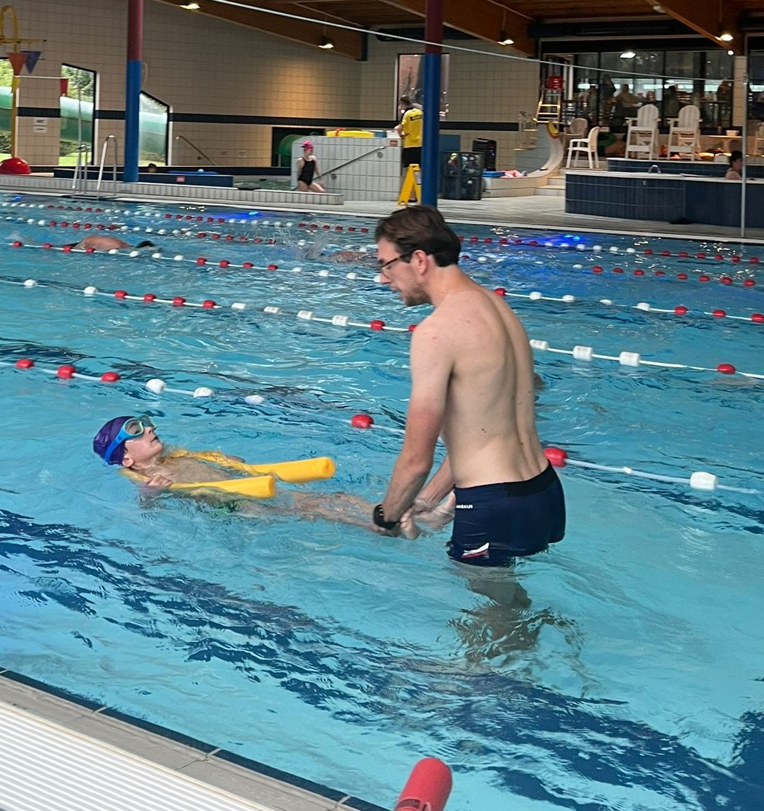 Gediplomeerd zweminstructeur geeft persoonlijke begeleiding aan kind tijdens zwemles