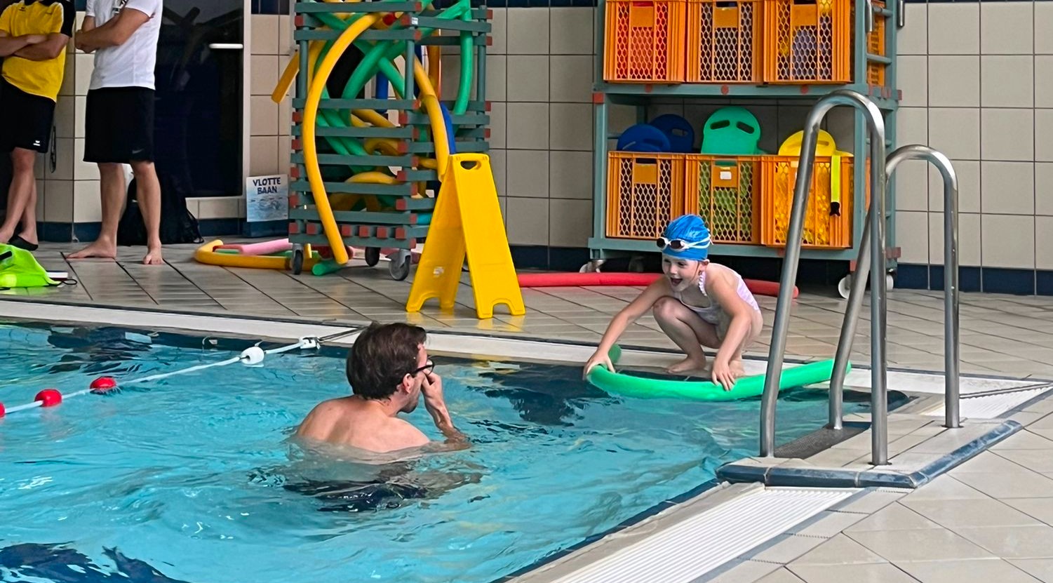 Kind oefent schoolslag techniek met zwemnoodle tijdens privé zwemles